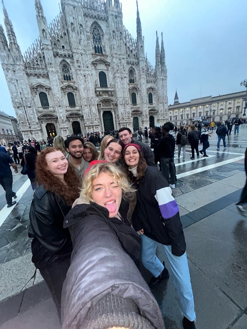 Group selfie in a crowded urban setting.