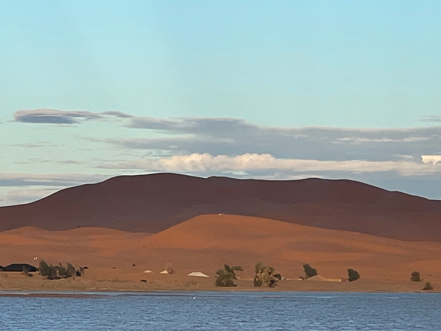 Desert landscape with sand dunes under blue sky.
