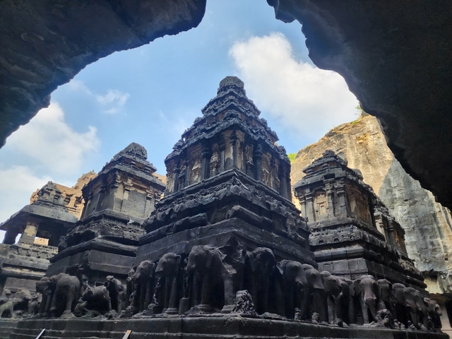 Ancient temple with ornate sculptures seen through an archway.