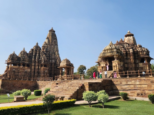       People visiting ancient, intricately carved stone temples.
  