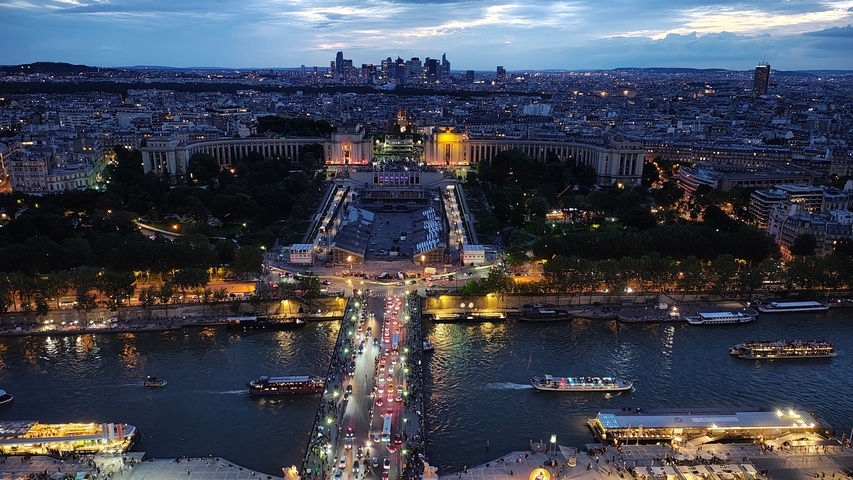       Aerial night view of Paris with the Seine River and city lights.
  