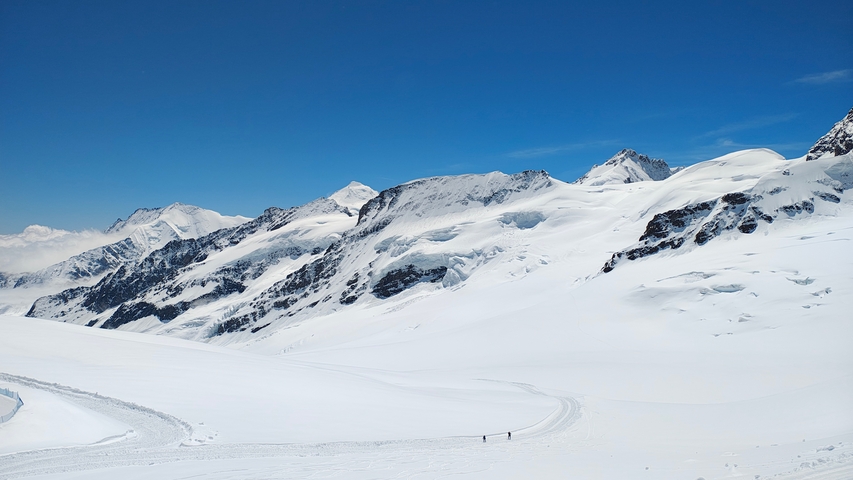 Snow-covered mountains under a clear blue sky.