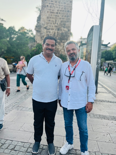       Two men standing outside near a street.
  