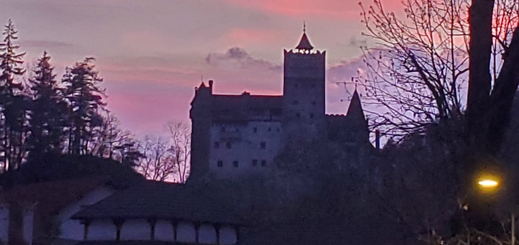       Silhouette of a castle with a colorful sunset sky.
  