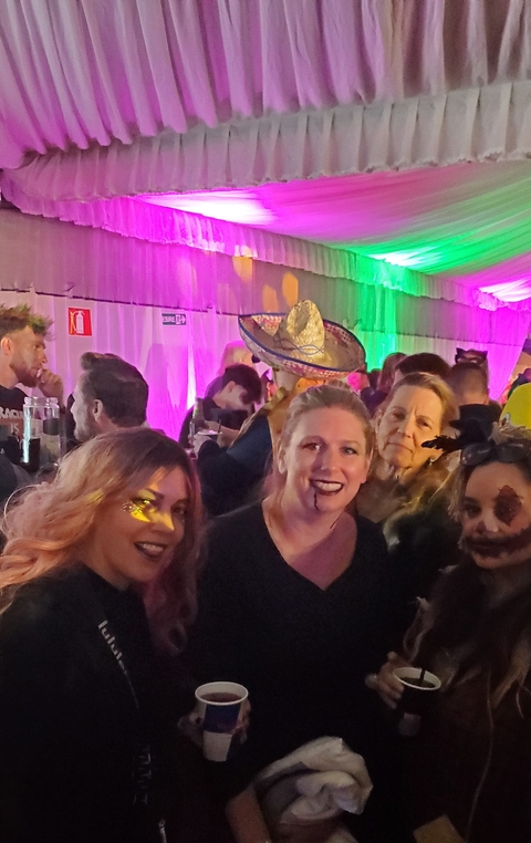       People at a party with colorful lights and decorations.
  