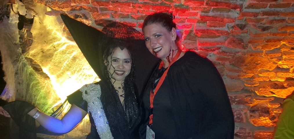 Two people in costumes posing at a Halloween-themed event.