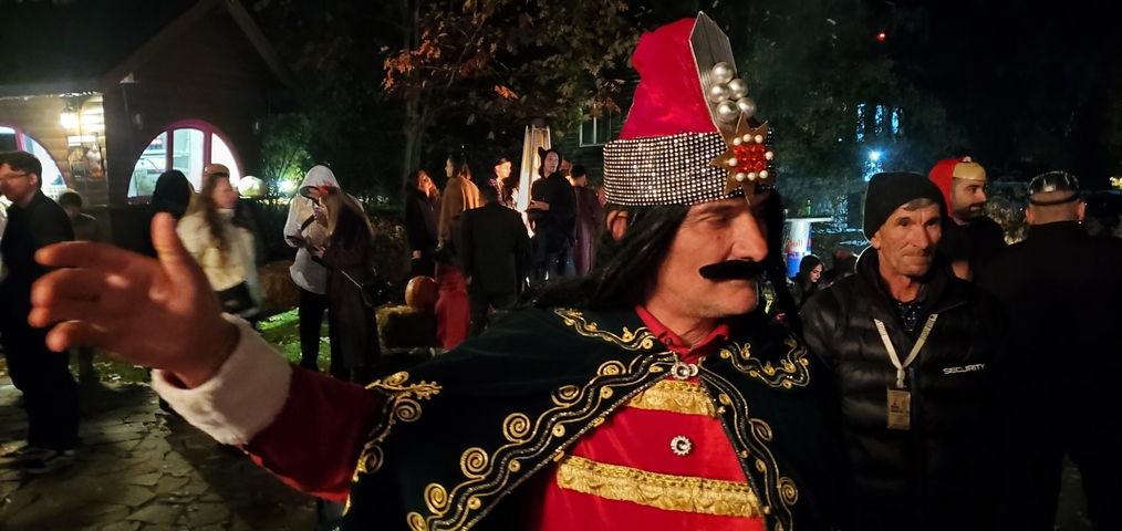       Person dressed in a historic costume at a night event.
  