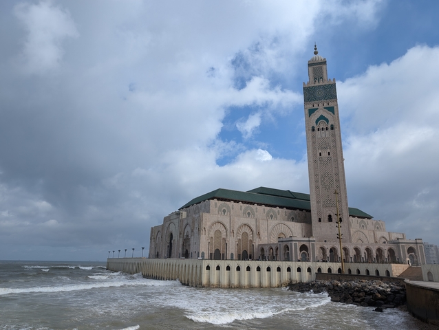       Hassan II Mosque against a cloudy sky.
  