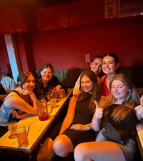 Group of friends sitting at a table with drinks in a pub.