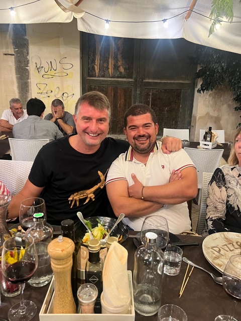 Group of people seated at a table enjoying food and drinks.