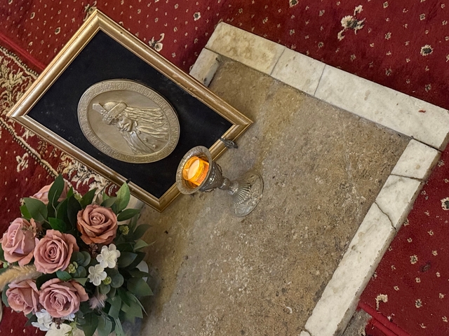 Grave with a candle and flowers.