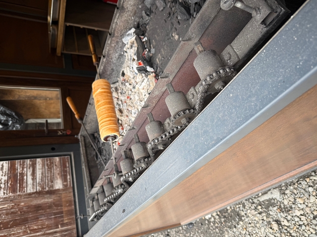       Trdelník cooking on a spit over charcoal.
  