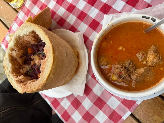 A bread bowl with soup displayed on a table.