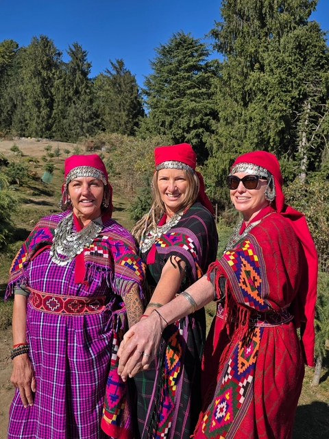 Three people wearing traditional attire posing.