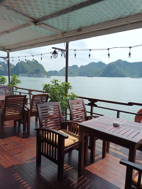 Deck of a cruise ship with dining tables and bay views