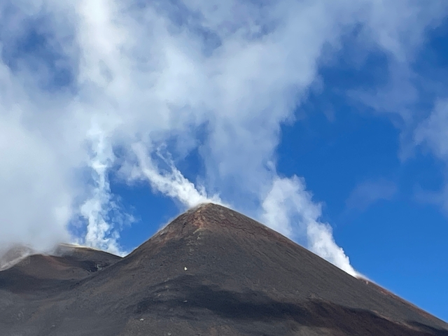       Smoking peak of a volcanic mountain under a clear sky
  