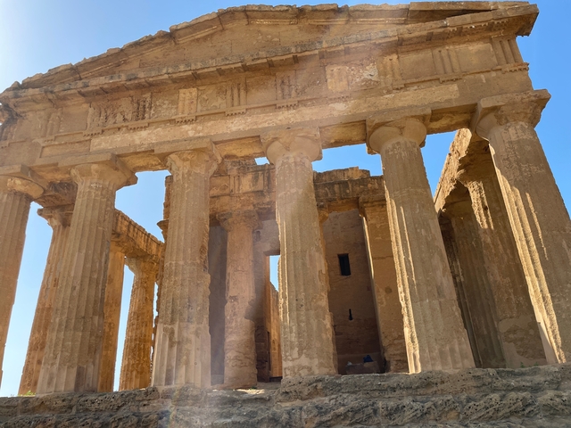       Ancient Greek temple ruins with sunlight illuminating columns
  