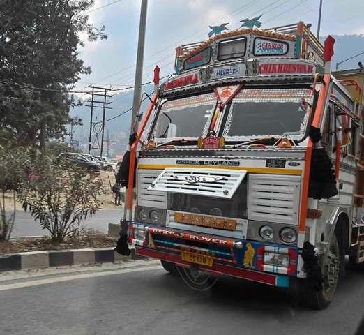       Colorfully decorated truck on a mountain road.
  
