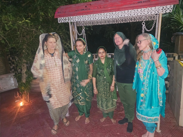 Group of people in traditional attire posing outdoors.