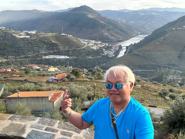 Person overlooking a scenic valley with a river.