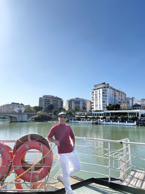 Person near a river with cityscape.