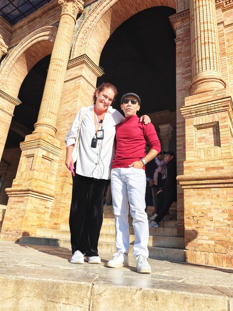 Two people posing outside a historic building.