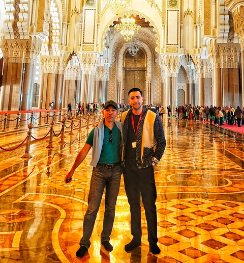 Two people standing inside an ornate building.