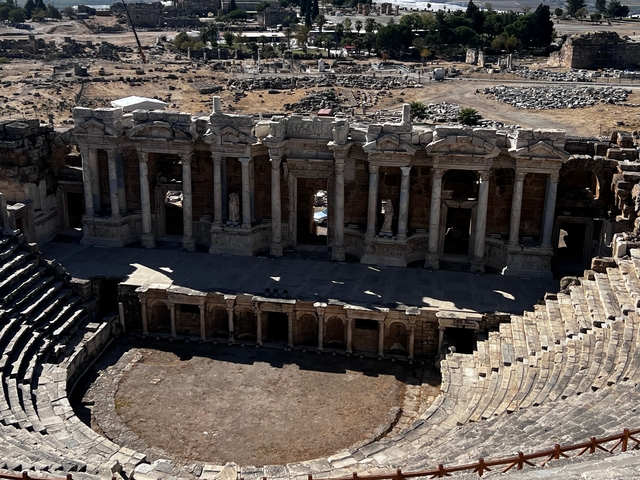       A well-preserved ancient amphitheater with seating and columns.
  