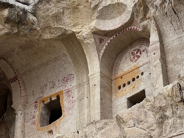       Ancient wall with intricate carvings and symbols.
  