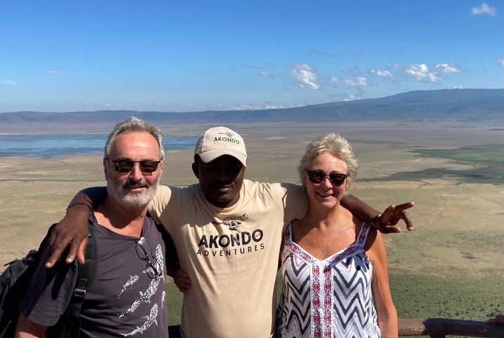 Three people posing at a scenic overlook with expansive views.