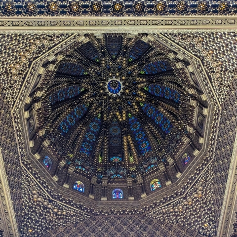 Intricate dome ceiling with stained glass windows.