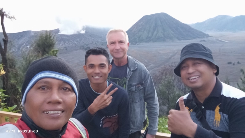 Group photo in front of a volcano with incorrect orientation.