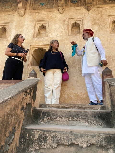 People standing on a staircase with a historic background.