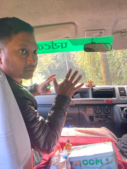       Person inside a vehicle gesturing with hands.
  