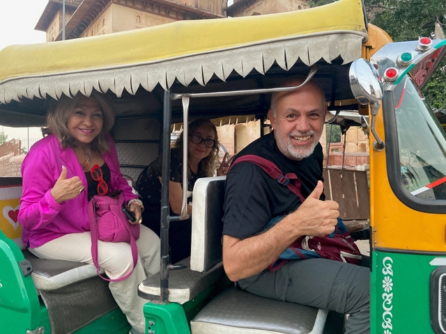       Group of people giving a thumbs-up inside a tuk-tuk.
  