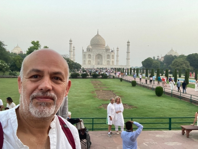 Man standing in front of the Taj Mahal.