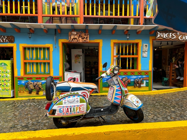 Colorful street facade with a vibrant scooter in front.