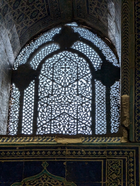       Detailed close-up of ornate latticework casting shadows.
  