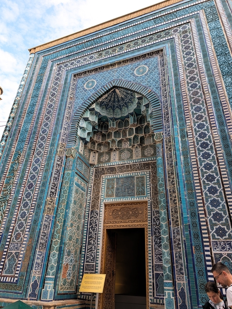 Intricate blue-tiled facade of an ancient building.