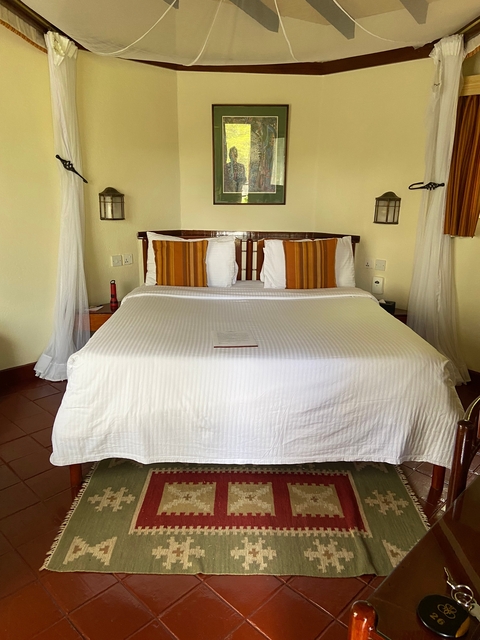       A neatly made bed in a cozy room with colorful pillows.
  