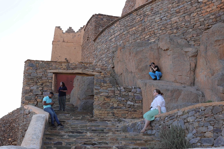       People exploring historical rocky architecture.
  
