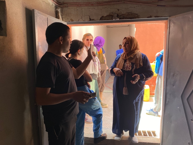 People in conversation under a shaded area.
