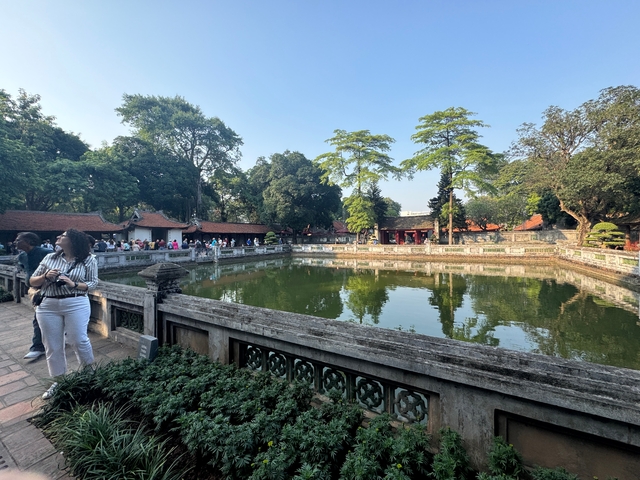 Pond surrounded by trees and tourists.