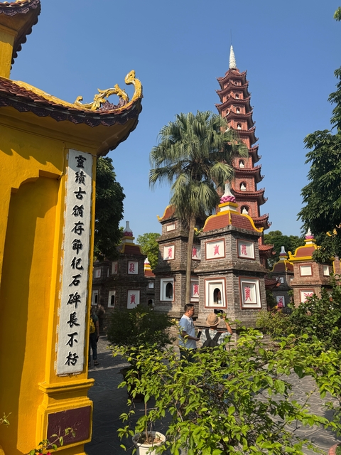 Pagoda with colorful structures surrounded by greenery.