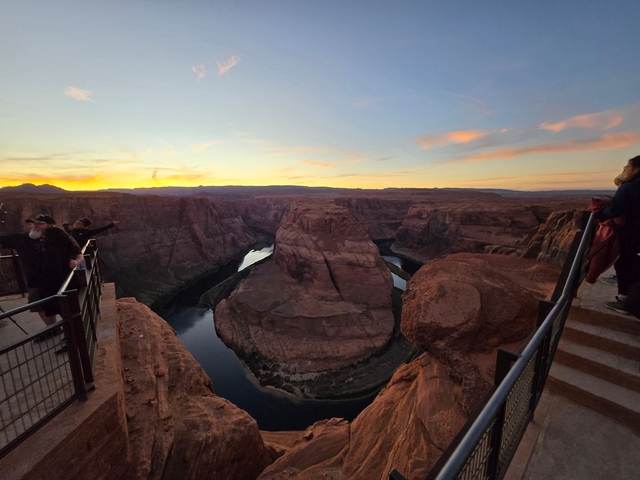 Scenic view of a large river bend at sunset with people