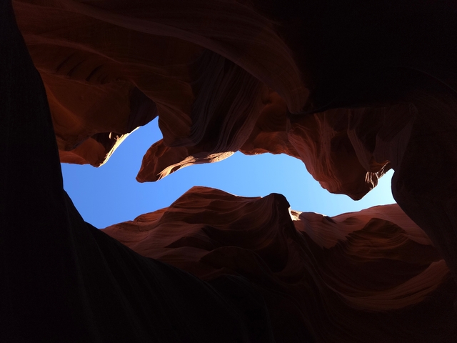Sandstone formations with sky visible through narrow openings.