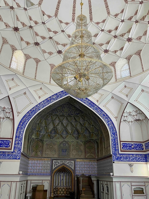       Interior of a building with intricate ceiling and chandelier.
  