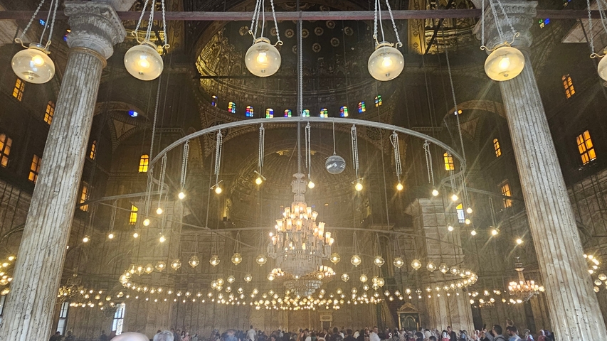       Interior of a mosque with chandeliers and arches.
  