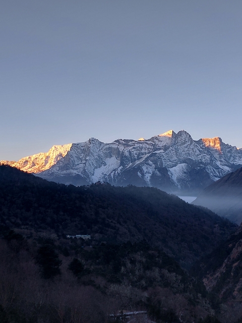       Sunlit mountain range with snow.
  