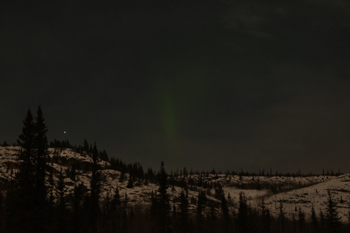 Night sky with northern lights over a snowy landscape.